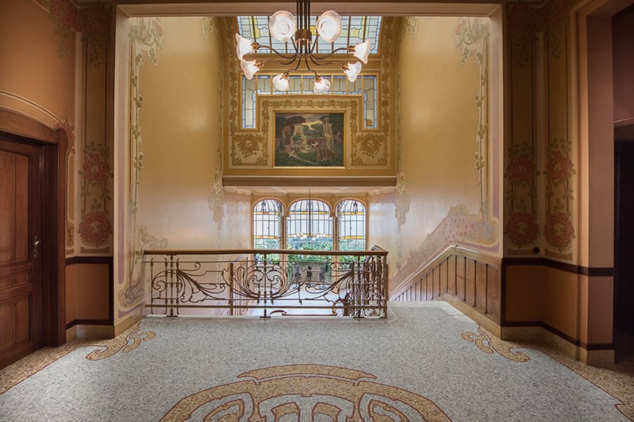 Ancienne salle de l'ANTÉ Festival à Bruxelles avec décoration élégante et fenêtres artistiques.