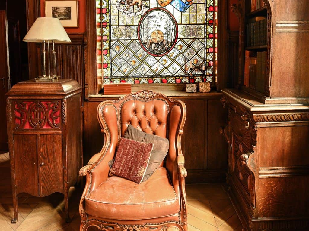 Fauteuil en cuir dans une chambre d'hôtel avec vitrail coloré en arrière-plan.